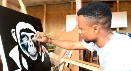 André Miguel peint un tableau dans son atelier © Glodi Mirembe